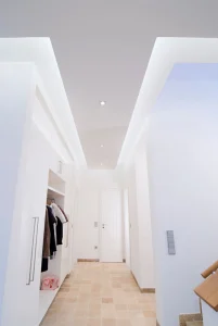 Moderner, heller Flur mit Kleiderschrank, Treppe und geschlossener Tür; minimalistisch und einladend.